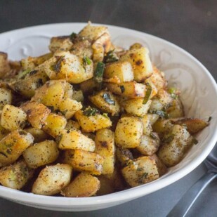 white bowl of low FODMAP home fries with serving spoon