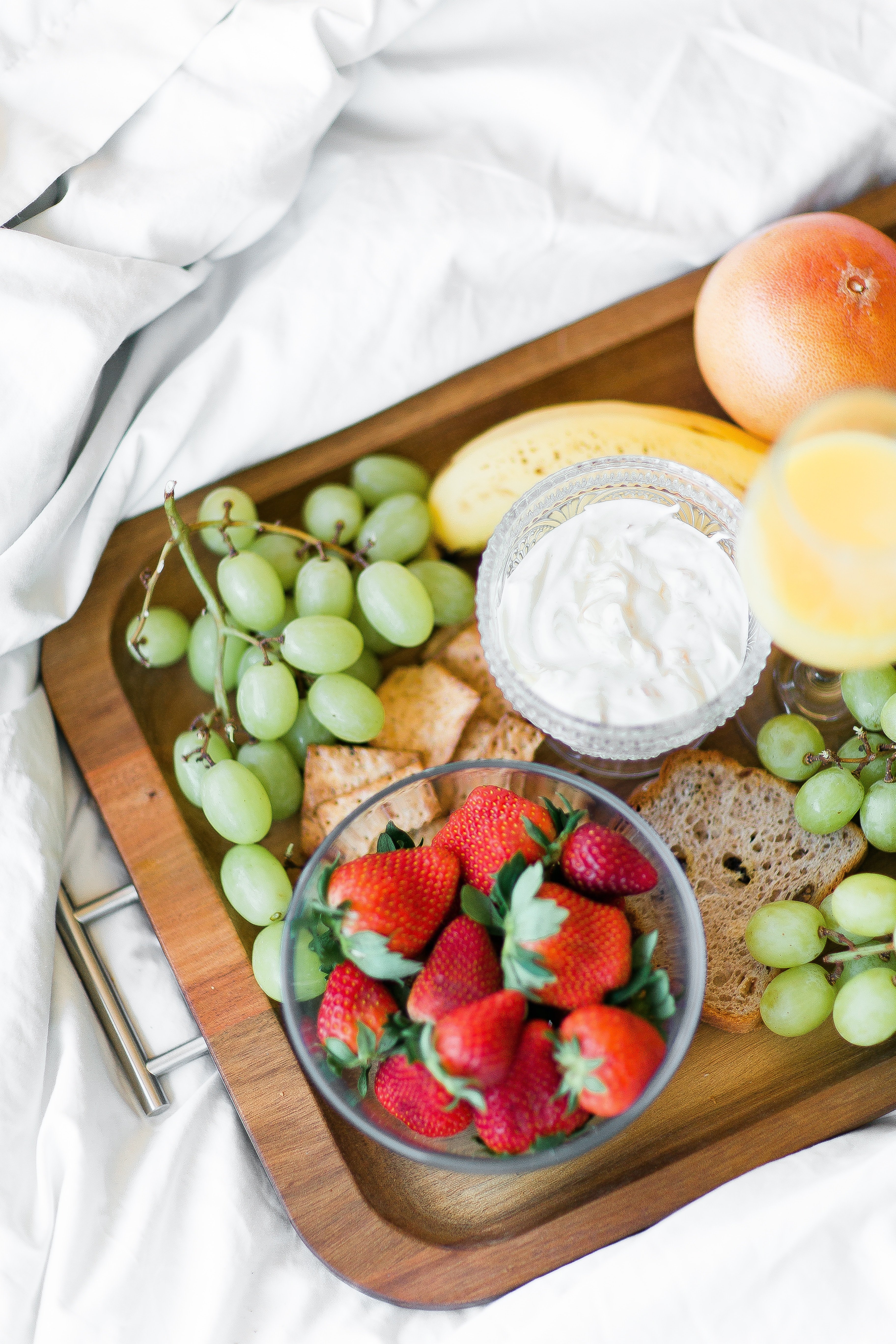 room service tray filled with fruit, crackers, bread and yogurt room service tray filled with fruit, crackers, bread and yogurt