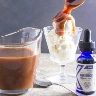 low FODMAP CBD Oil salted caramel sauce dribbling off of a spoon onto ice cream; elixinol CBD oil in foreground