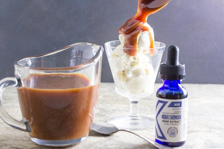 low FODMAP CBD Oil salted caramel sauce dribbling off of a spoon onto ice cream; elixinol CBD oil in foreground