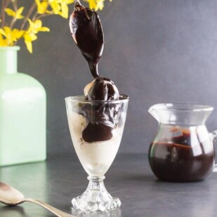 low FODMAP CBD oil Hot Fudge sauce dripping from spoon onto ice cream in glass dishCR2