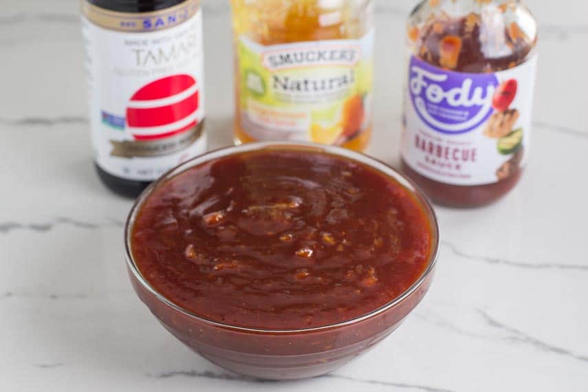 Low FODMAP Orange marmalade BBQ Sauce in glass bowl with ingredients in background