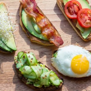 assorted low FODMAP avocado toast on a wooden board