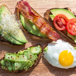 assorted low FODMAP avocado toast on a wooden board - great for breakfast, lunch or a snack