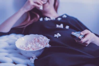 woman eating popcorn in bed