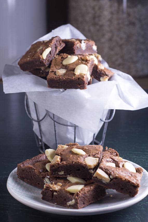 vertical image of low FODMAP Black & White Brownies on a plate in foreground and in a basket in background