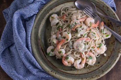 Low FODMAP Buffalo Shrimp Pasta on rustic ceramic plate