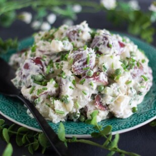 closeup of FODMAP IT!™ Potato Salad with Peas & Chives on a green plate