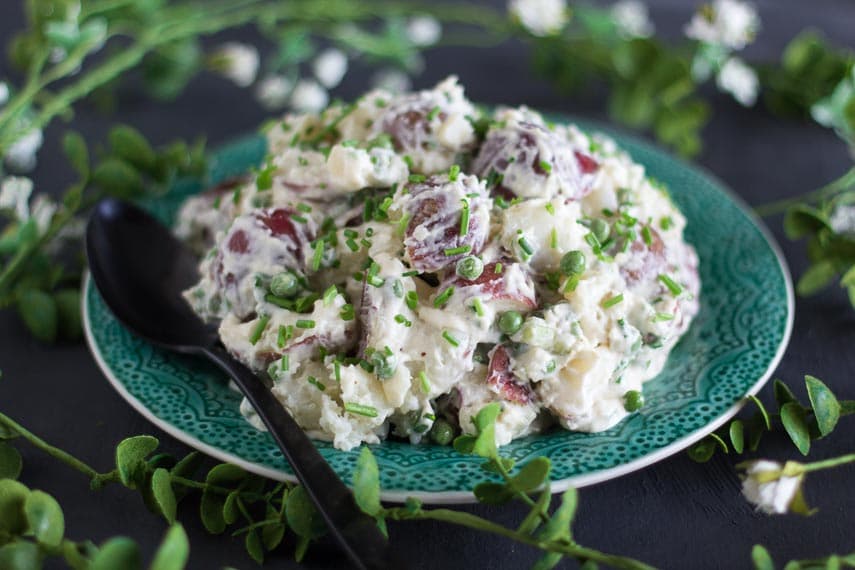 closeup of FODMAP IT!™ Potato Salad with Peas & Chives on a green plate