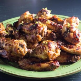closeup of Low FODMAP Honey Roasted Chili Lime Chicken Wings on green plate