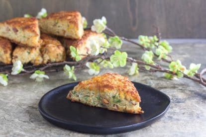 horizontal image of low FODMAP Ham & Cheese Scones on black plate, on stone surface