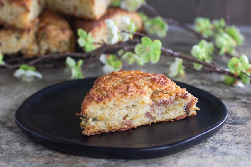 horizontal image of low FODMAP Ham & Cheese Scones on black wooden plate