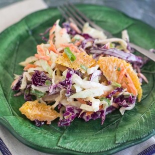 closeup of Low FODMAP Citrus Slaw with Creamy Grapefruit Dill Dressing on green plate
