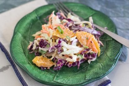 closeup of Low FODMAP Citrus Slaw with Creamy Grapefruit Dill Dressing on green plate