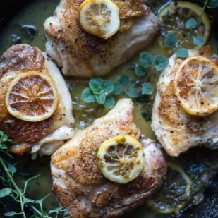 low FODMAP chicken thighs with lemon and fresh oregano in a cast-iron pan