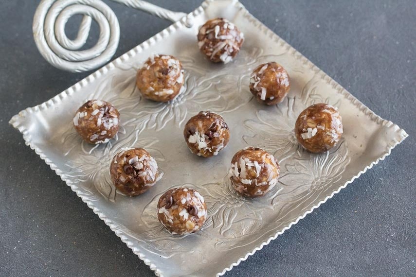 Low FODMAP Almond Joy Energy Bites on square aluminum platter against dark background