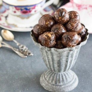 Low FODMAP Mocha Espresso Power Balls in a grey aluminum footed dish; coffee cups and spoons in background