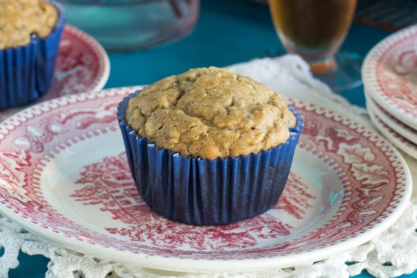 Low FODMAP High Protein Peanut Butter Muffins in a blue paper wrapper on a red and white antique plate