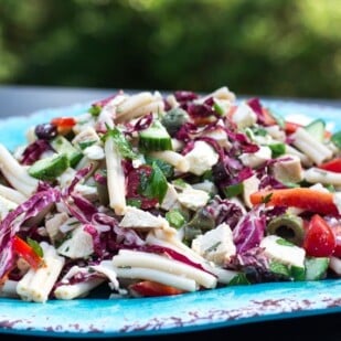 close side view of Low FODMAP Mediterranean Pasta Salad on an oval aqua platter