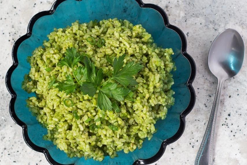 overhead image of low FODMAP Cilantro Lime Rice in aqua blue fluted glass bowl on grey quartz speckled countertop