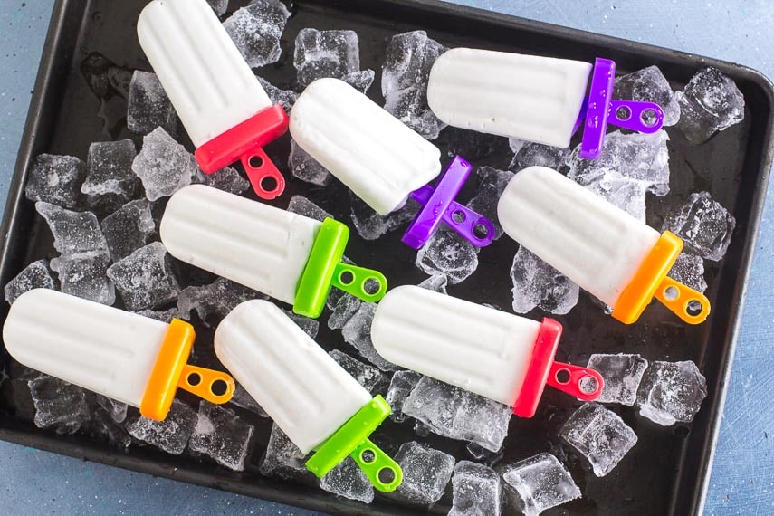 overhead view of Low FODMAP coconut popsicles on ice filled dark tray
