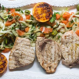 P Grilled Swordfish with Grilled Orange, Fennel and Green Olive Salad on a rectangular white platter