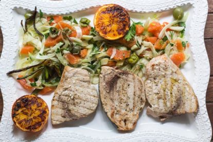 P Grilled Swordfish with Grilled Orange, Fennel and Green Olive Salad on a rectangular white platter