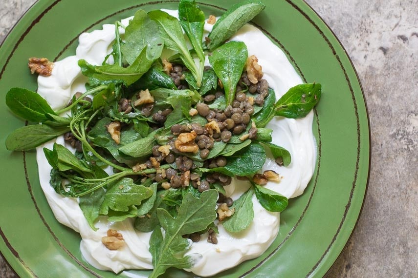 Low FODMAP Lentil Salad with Greens on a green plate; tile surface