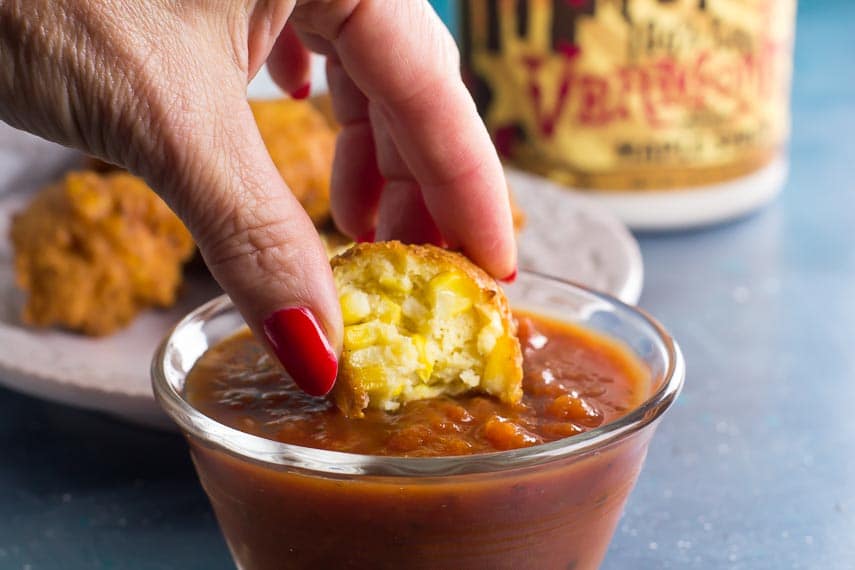 low FODMAP corn fritters being dipped into salsa