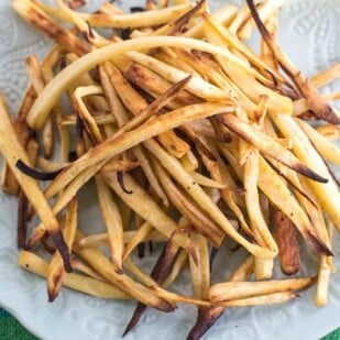 low FODMAP parsnip fries on white plate an aqua tablecloth