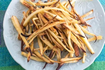 low FODMAP parsnip fries on white plate an aqua tablecloth