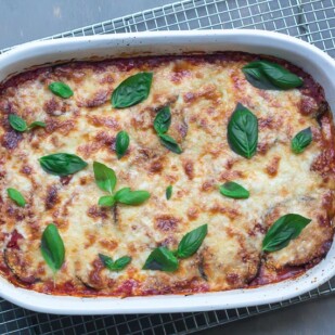 overhead view of low FODMAP eggplant parmigiana in white casserole on cooling rack