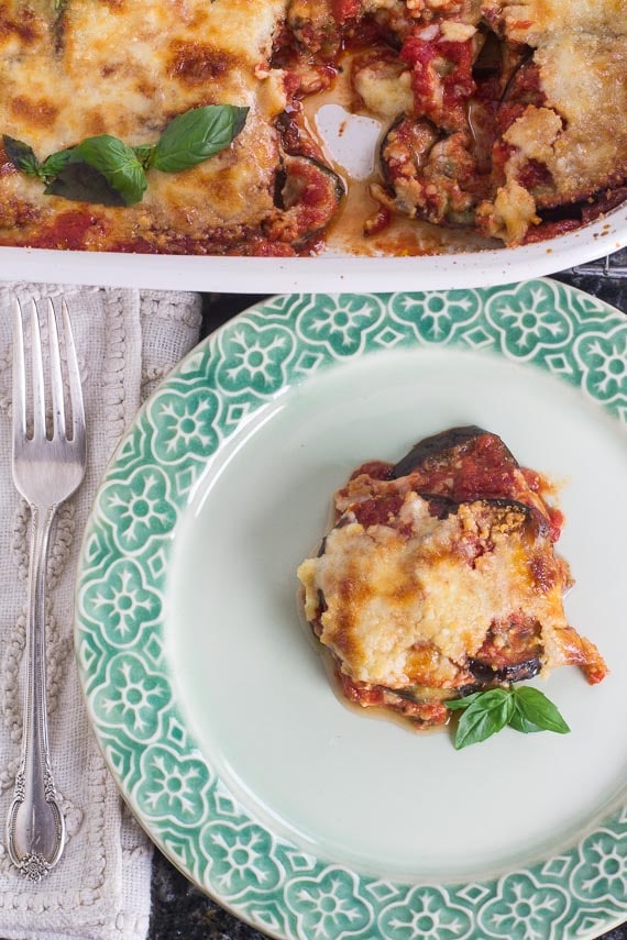 vertical image of low FODMAP eggplant parmigiana on green decorative plate
