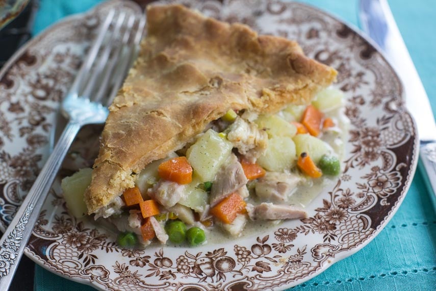Low FODMAP Chicken Pot Pie slice on brown decorative plate on teal cloth