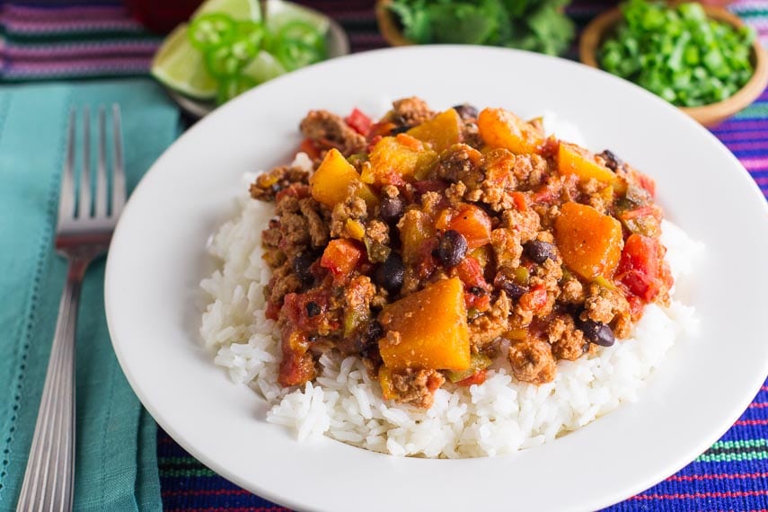 Low FODMAP Turkey Chili with Winter Squash & Beans with rice in a white bowl