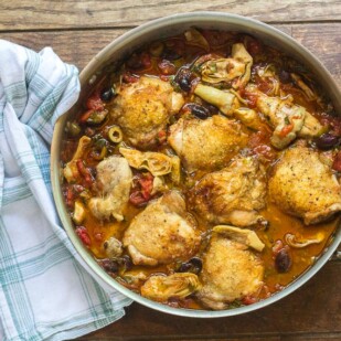 One-Pan Low FODMAP Chicken, Artichokes & Olives in pan on wooden surface