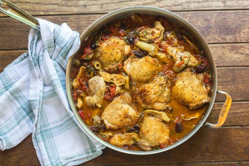 One-Pan Low FODMAP Chicken, Artichokes & Olives in pan on wooden surface