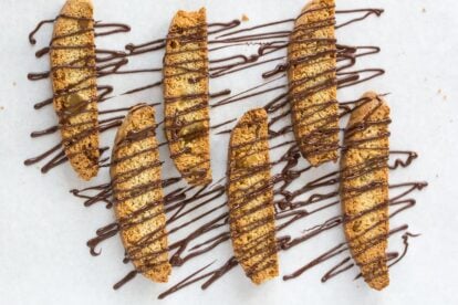 low FODMAP triple ginger biscotti drizzled with chocolate on parchment lined pan
