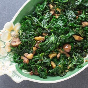 overhead view of Garlicky Low FODMAP Sautéed Kale with Chestnuts in oval decorative bowl