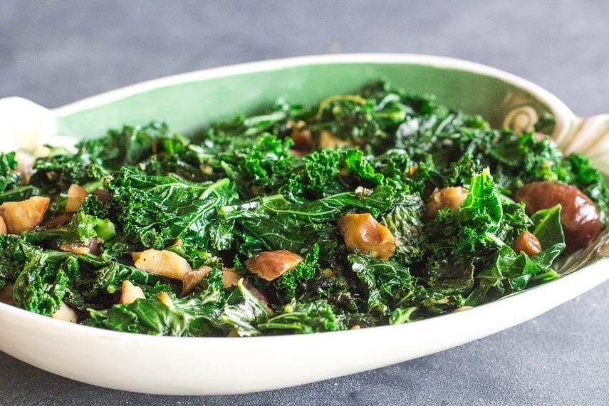 side view of Garlicky Low FODMAP Sautéed Kale with Chestnuts in oval dish