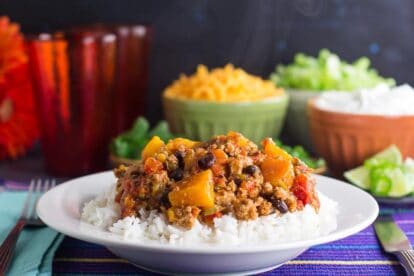 side view of Low FODMAP Turkey Chili with Winter Squash & Beans with rice in a white bowl