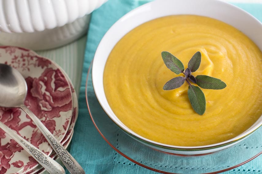 white bowl containing No FODMAP Root vegetable Soup with fresh sage garnish