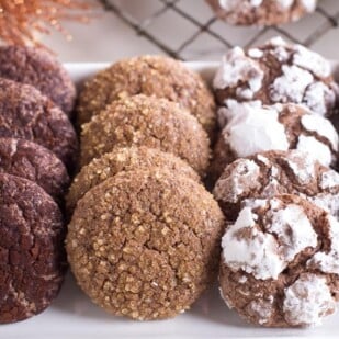 Low FODMAP Chocolate Crinkle Cookies on white platter with various toppings