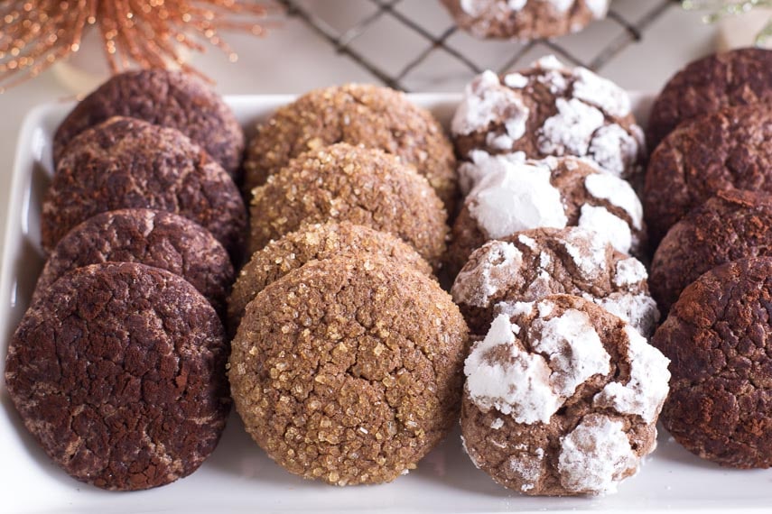 Low FODMAP Chocolate Crinkle Cookies on white platter with various toppings