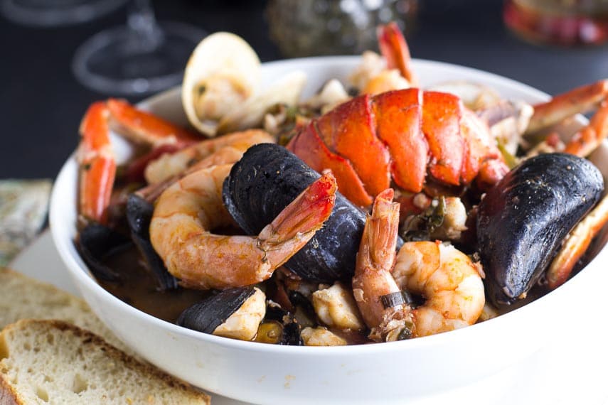 Low FODMAP Cioppino in white bowl with sourdough bread