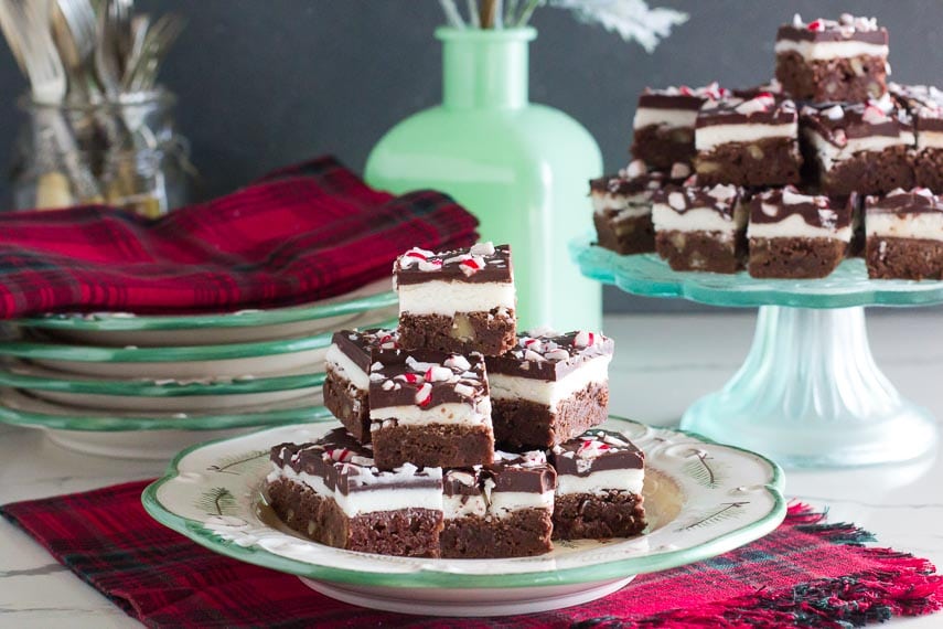 Low FODMAP Peppermint Brownies on a plate and pedestal, against a holiday table tableau