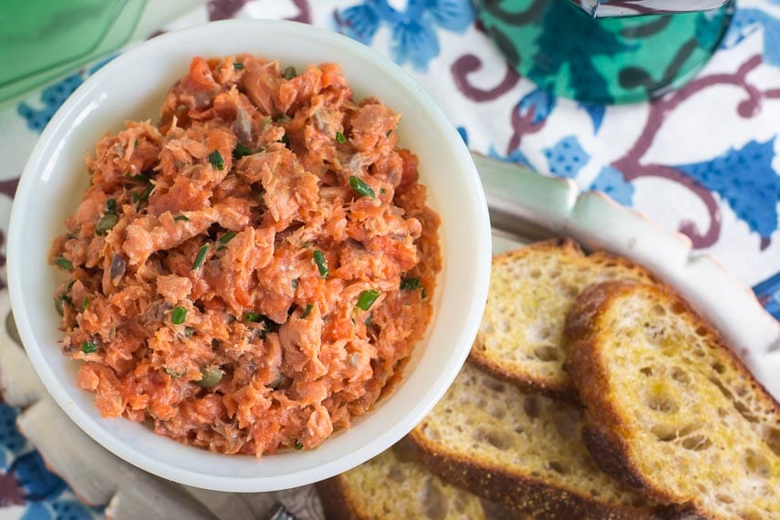 closeup of vertical image of low FODMAP Salmon Rillettes in white bowl; toasted baguette alongside