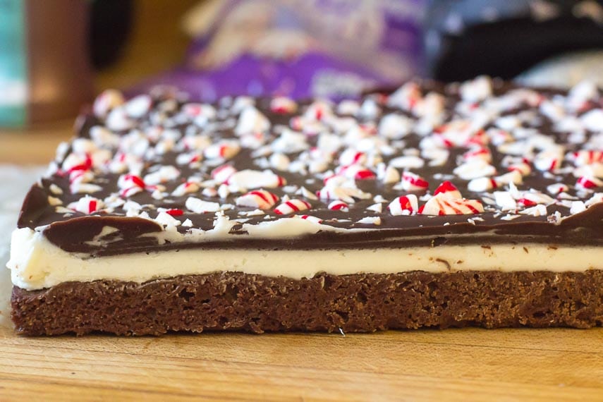 side view of layers of Low FODMAP Peppermint Brownies on wooden board
