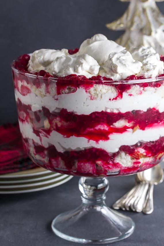 vertical image of low FODMAP Cranberry Raspberry Cheesecake Trifle in glass trifle bowl