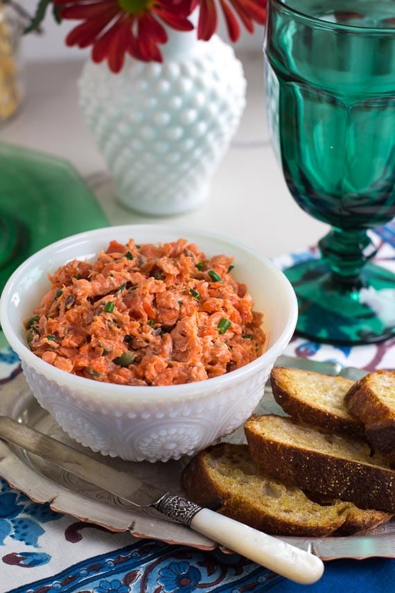 vertical image of low FODMAP Salmon Rillettes in white bowl; teal glass alongside